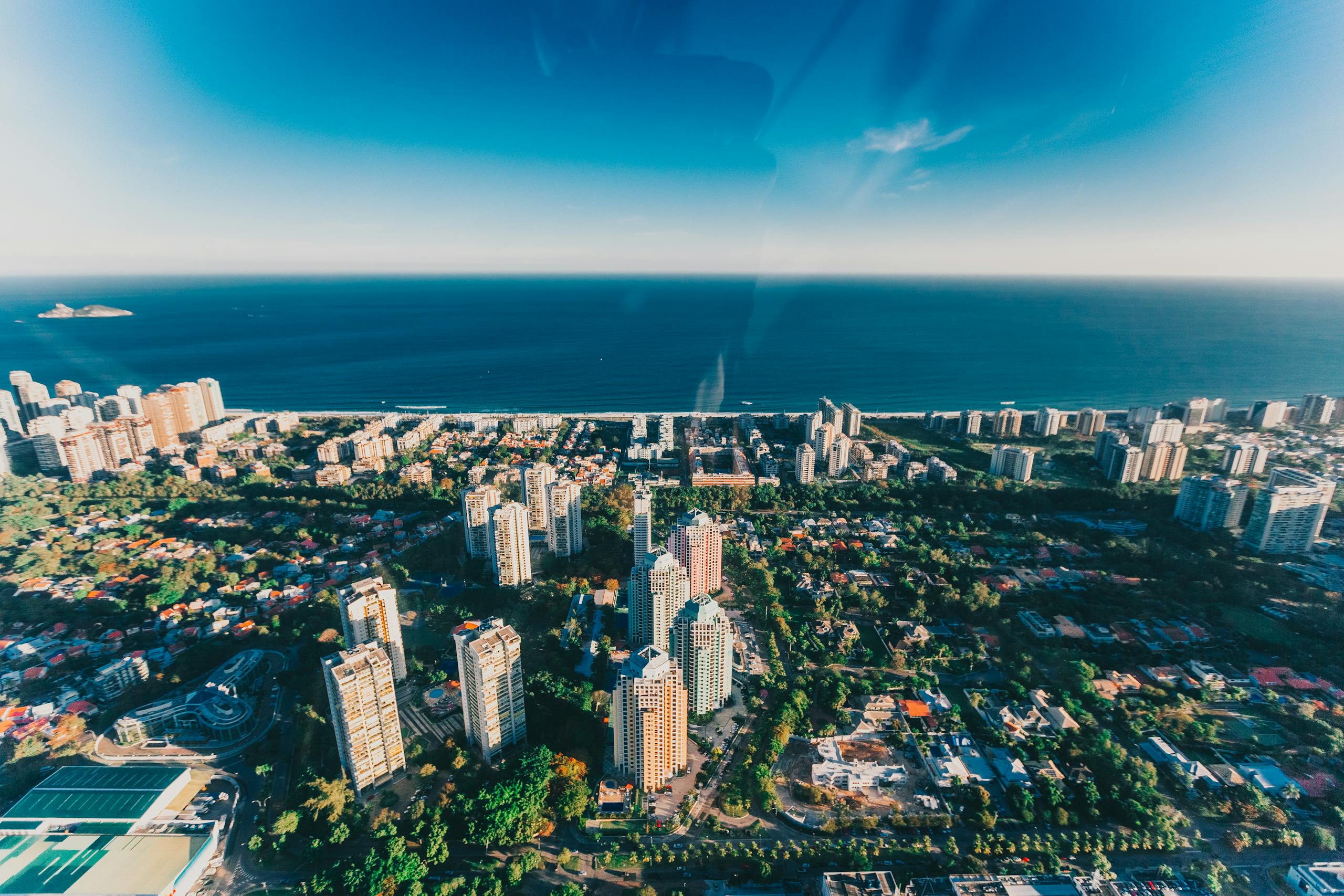 Stunning aerial view of Rio de Janeiro's skyline and ocean horizon under clear skies.